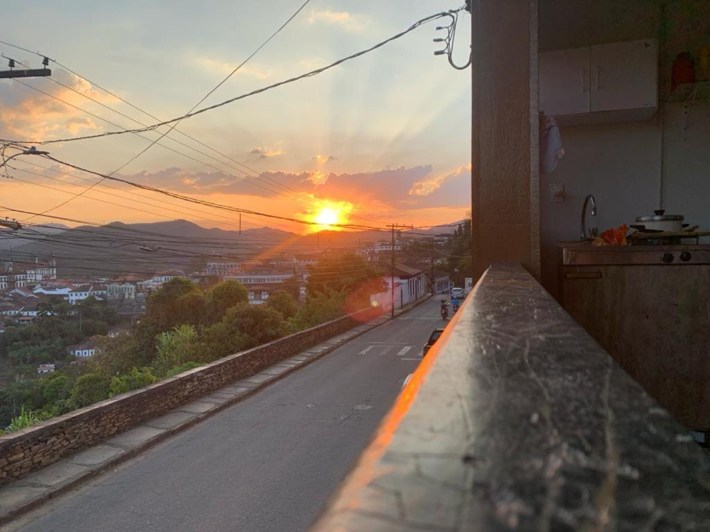 einen Blick auf den Sonnenuntergang vom Balkon eines Gebäudes in der Unterkunft Hostel do Mirante in Ouro Preto