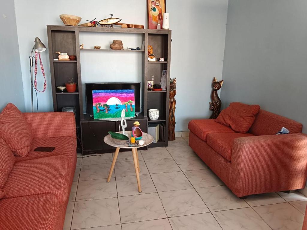 uma sala de estar com dois sofás vermelhos e uma televisão em Departamento pucarani em Arica