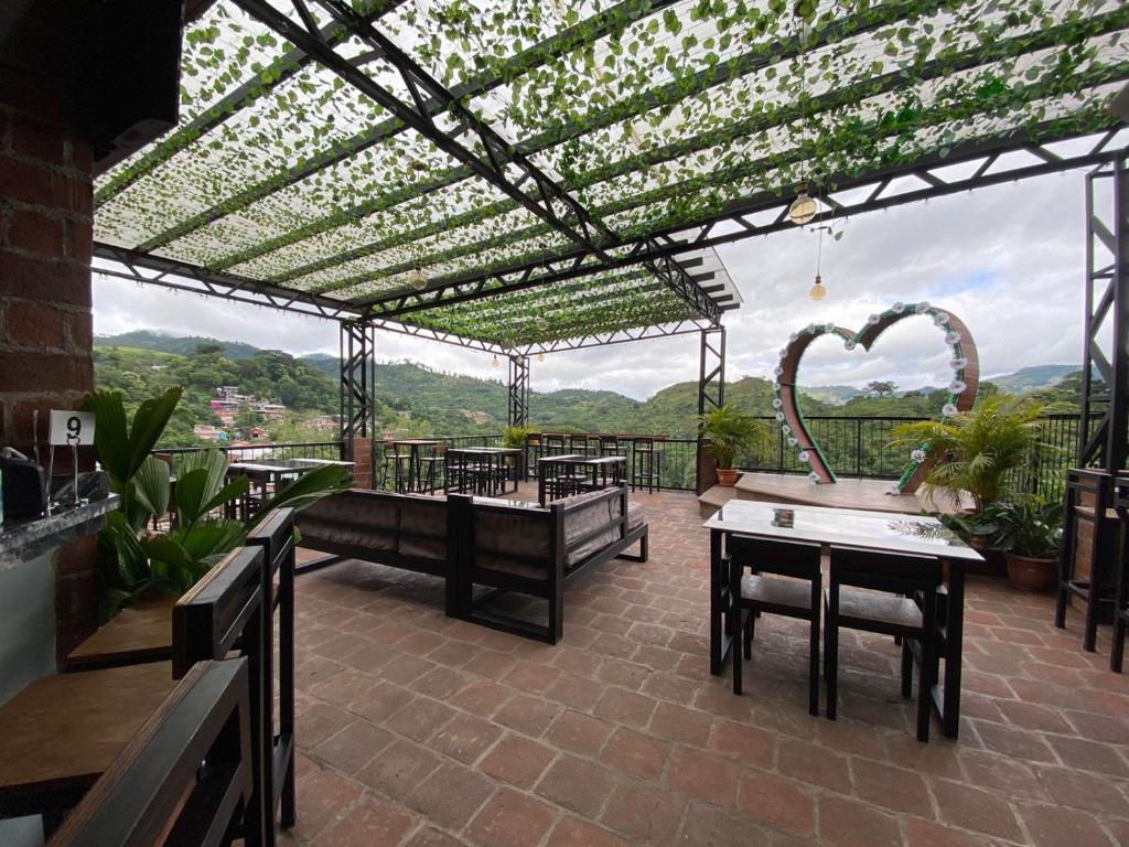 une terrasse avec une pergola, des tables et des chaises dans l'établissement Hotel, Restaurante y Bar Sofmel, à Copan Ruinas