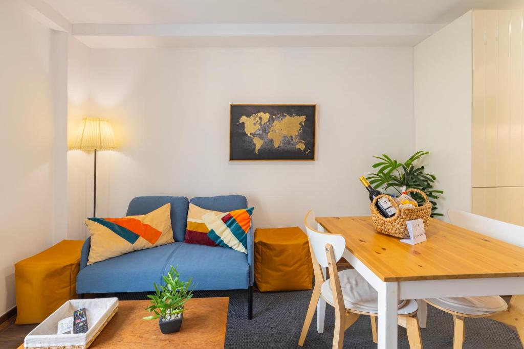 a living room with a blue couch and a table at Cosy Remodeled apartment in the City center in Fundão