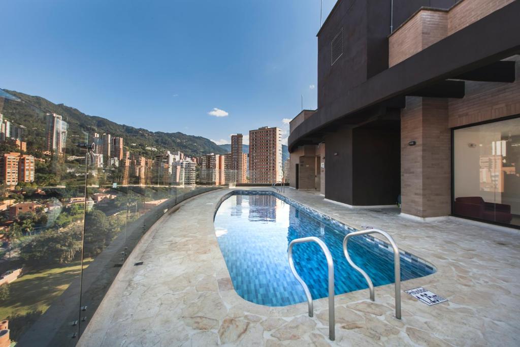 une piscine au milieu d'un immeuble dans l'établissement CLASS DE SUITES DE LUJO EL POBLADO. EXCELENTE UBICACIÓN, à Medellín