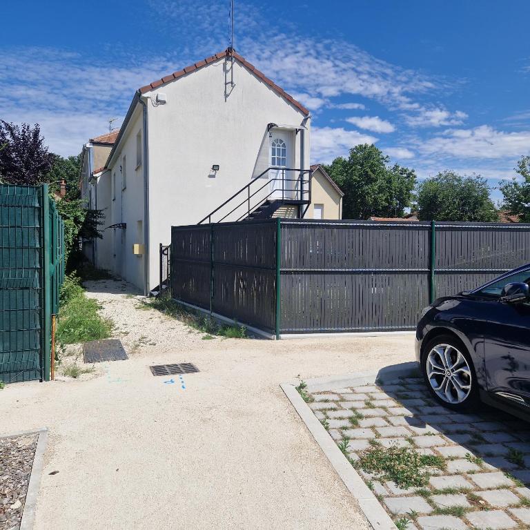 une voiture garée devant une maison avec une clôture dans l'établissement 15 minutes du centre-ville, à Troyes