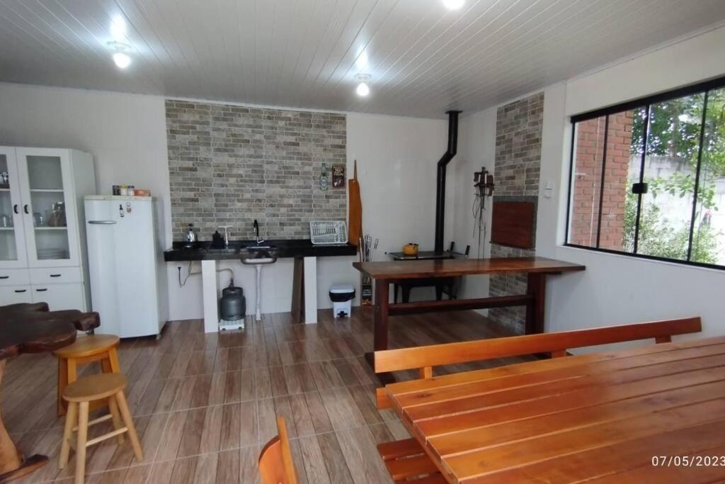 a kitchen with a bench and a table and a refrigerator at Edícula familiar - Ao lado BR277 in Guarapuava