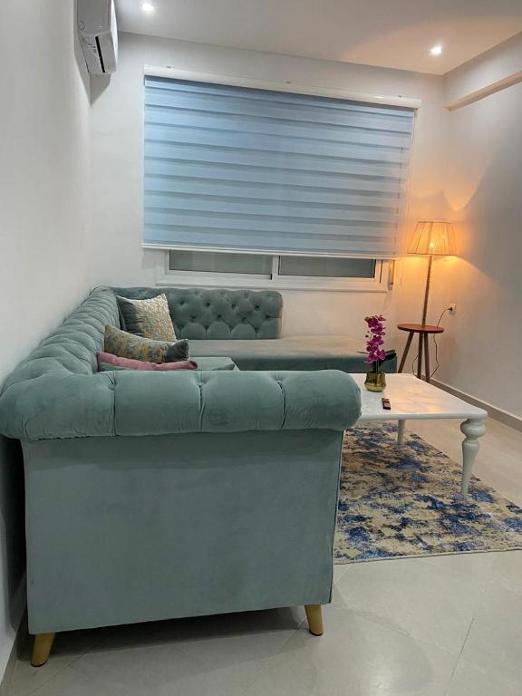 sala de estar con sofá azul y mesa en LuxeNew, en Tánger