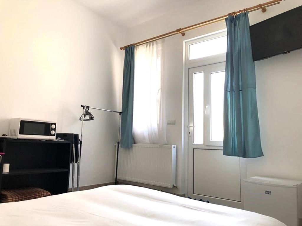 アズガにあるCasa Centralaのベッドルーム1室(青いカーテンと窓付きのベッド1台付)