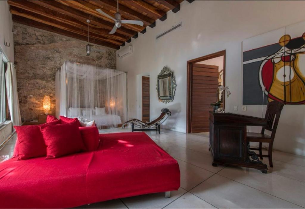 a large red bed in a room with a piano at Casa de los sueños in Cartagena de Indias