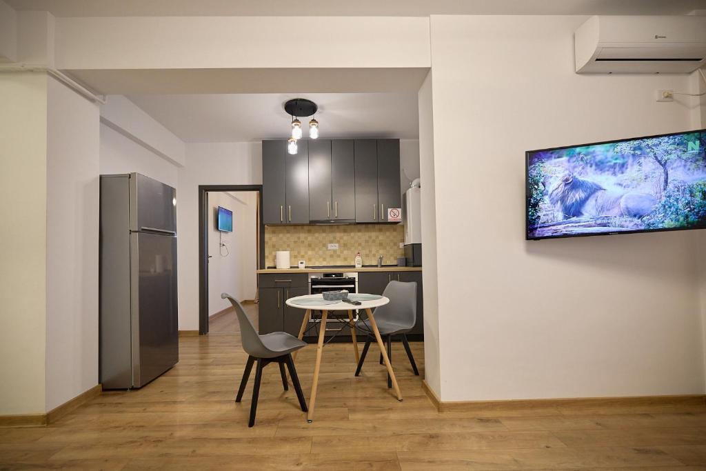 una cucina con tavolo, sedie e frigorifero di Alessandro Home 11 Luxury Centru Palas Mall Iași Q Residence a Iaşi