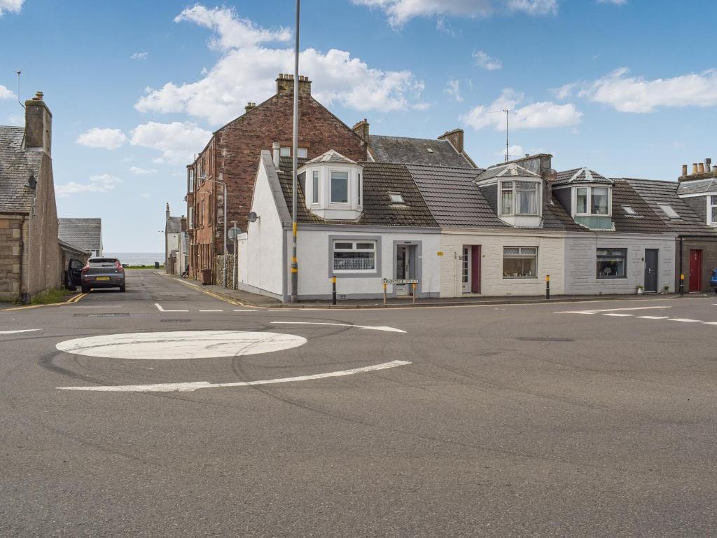 an empty street in front of a white building at Corner Cottage in Girvan