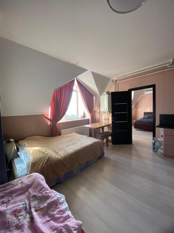 a bedroom with two beds and a desk and a window at Moldova Balți center in Bălţi