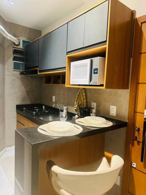 Hotel Apartamento luxuoso em Ipanema, a kitchen with a counter with two sinks and a microwave at Apartamento luxuoso em Ipanema in Rio de Janeiro