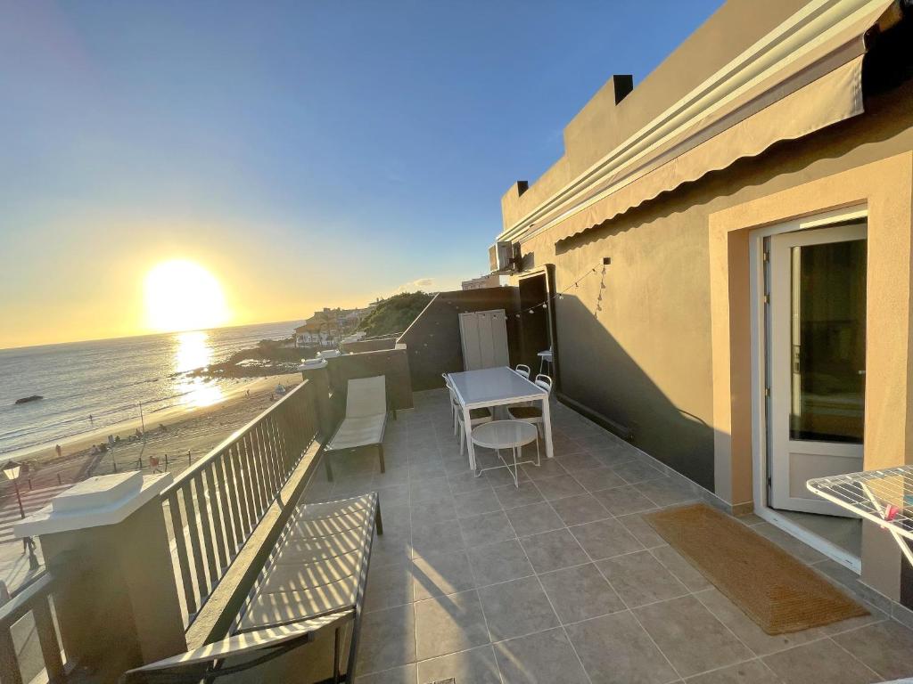 a balcony with a table and chairs and the beach at Casa Arjuna in Valle Gran Rey