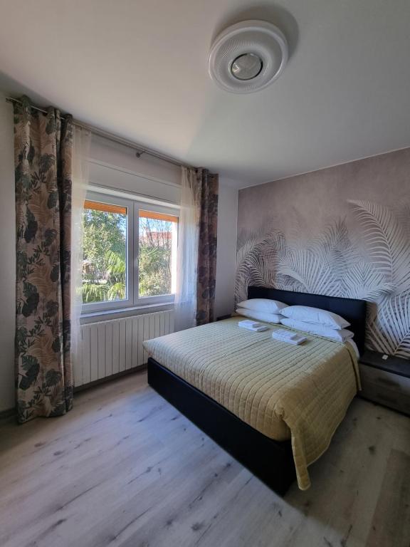 Bilocale Villesse : غرفة نوم بسرير ونافذة