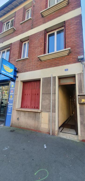 a brick building with a red door and a garage at RELAX in Montreuil
