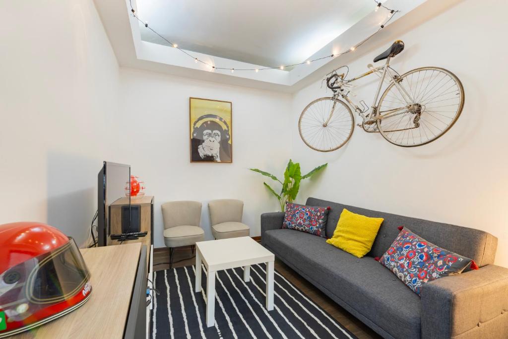 a living room with a couch and a bike hanging on the wall at Remodeled historical apartment in the City center in Fundão