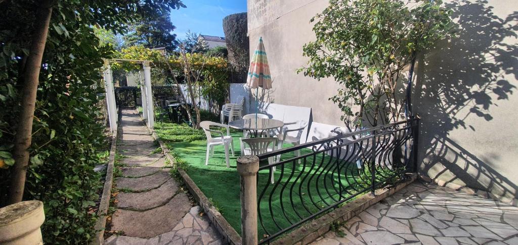 a fence with a table and chairs and an umbrella at RELAX in Montreuil