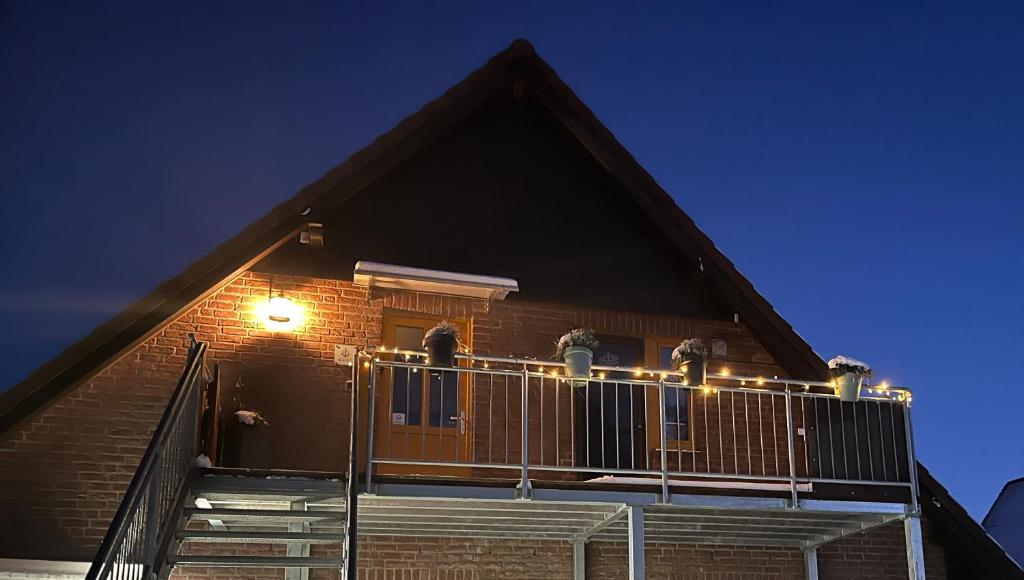 a house with a balcony with a light on it at Ferienwohnung Kalle in Osterbruch