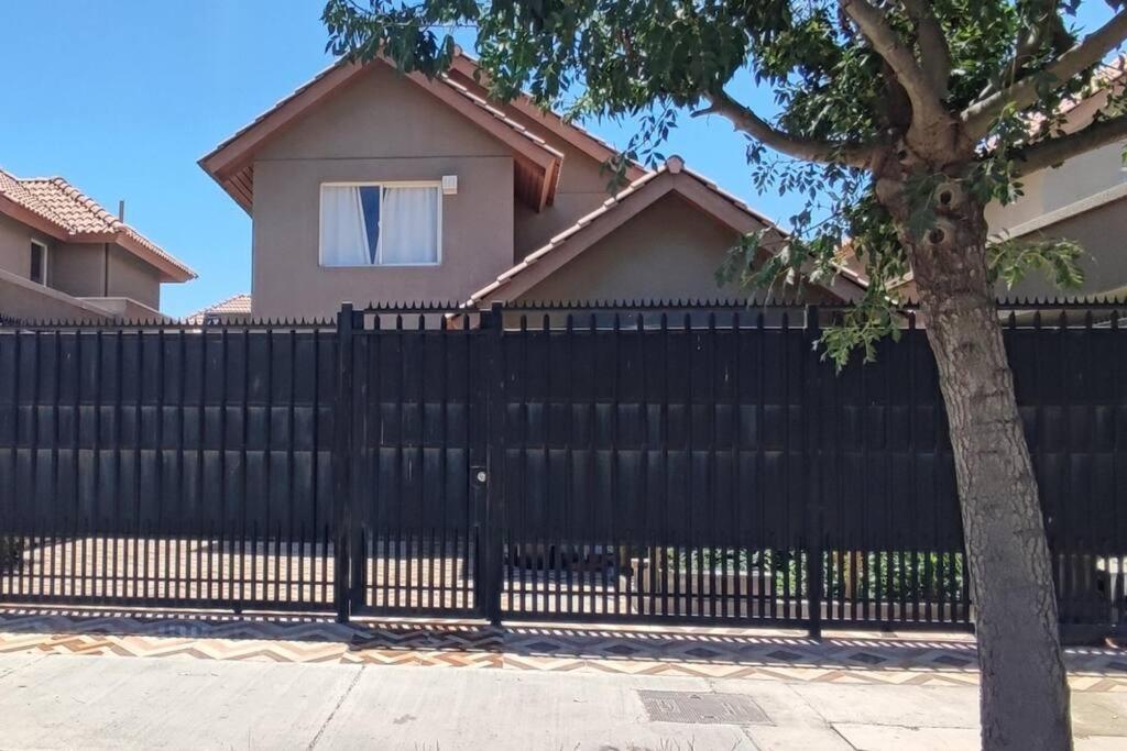 a black fence in front of a house at Beautiful Confortable House in Estación Colina