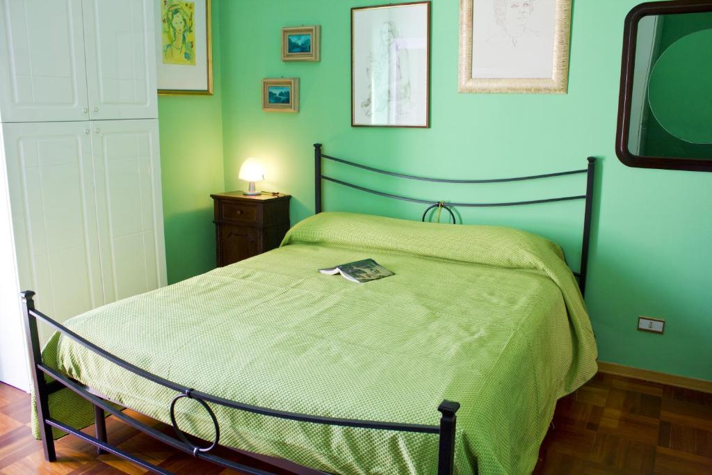 a green bedroom with a bed and a television at La Bertina in Montefiascone