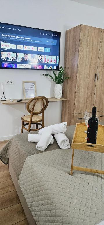 een slaapkamer met een bed met een tafel en een televisie bij Bllok Scandi Urban Apartments 1 in Tirana