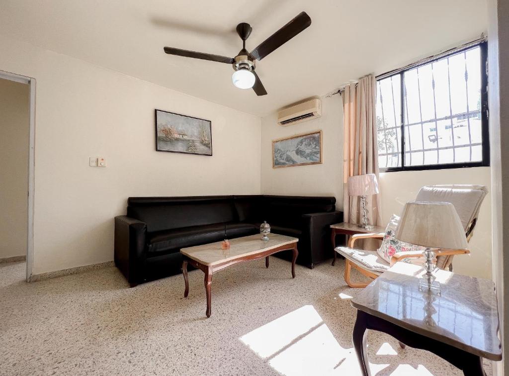 un soggiorno con divano nero e tavolo di Nice Central Studio Apartment a Santo Domingo