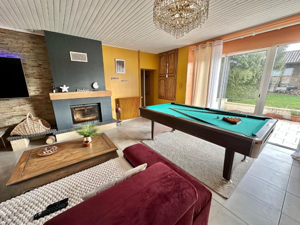 a living room with a pool table and a couch at Grande Maison familiale bien équipée avec Billard in Chaunay