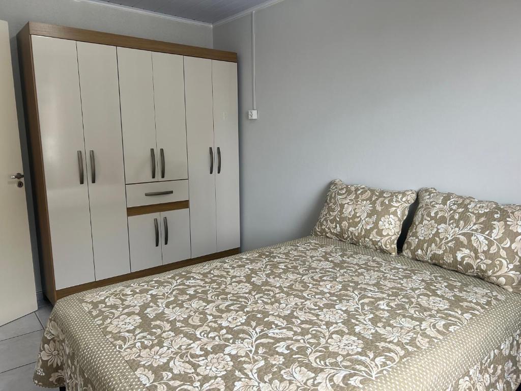 1 dormitorio con 1 cama y armario blanco en Casa completa - Governador Celso Ramos à 15min da praia de palmas, en Governador Celso Ramos