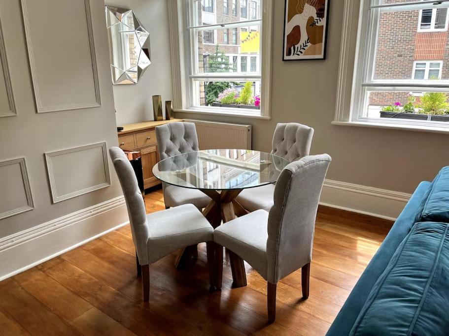 a dining room with a glass table and chairs at Stunning 2 bedroom Apartment in Marylebone High St in London