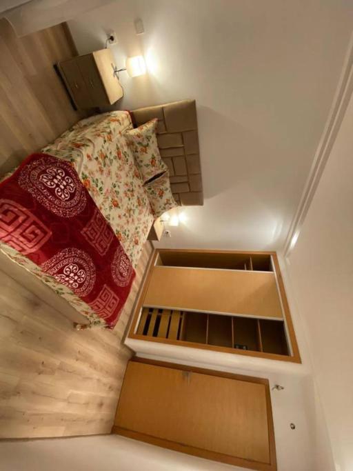 um pequeno quarto com uma cama com almofadas vermelhas em appartements Mohammedia/mansouria em Pont Blondin