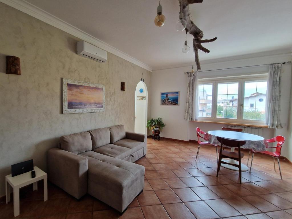 una sala de estar con un sofá y una mesa en Alloggio Turistico 3 minuti da aeroporto- Fiumicino centro, en Fiumicino
