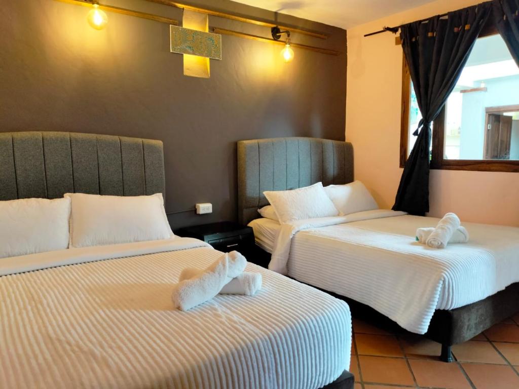 Habitación con 2 camas y toallas. en Hotel PiedradeLuna en Villa de Leyva