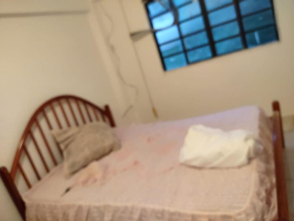 a small bed in a room with a window at Pousada Arvoredo in Contagem