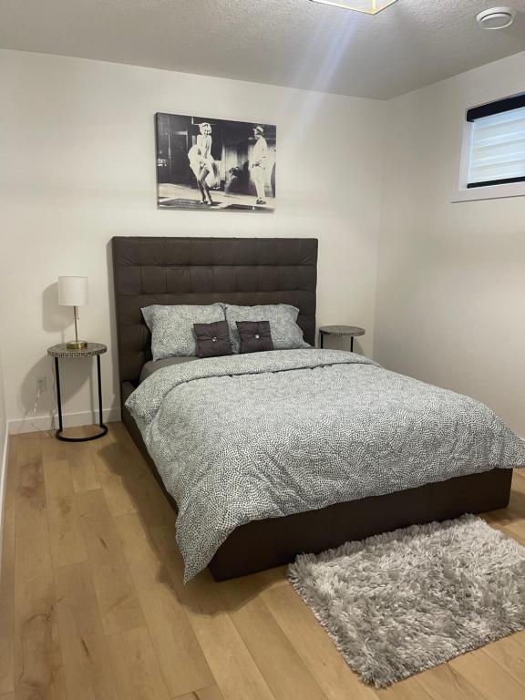 a bedroom with a large bed and two pictures on the wall at Stylish 2 Bedroom suite in SW Edmonton close to Windermere and Edmonton International Airport in Edmonton