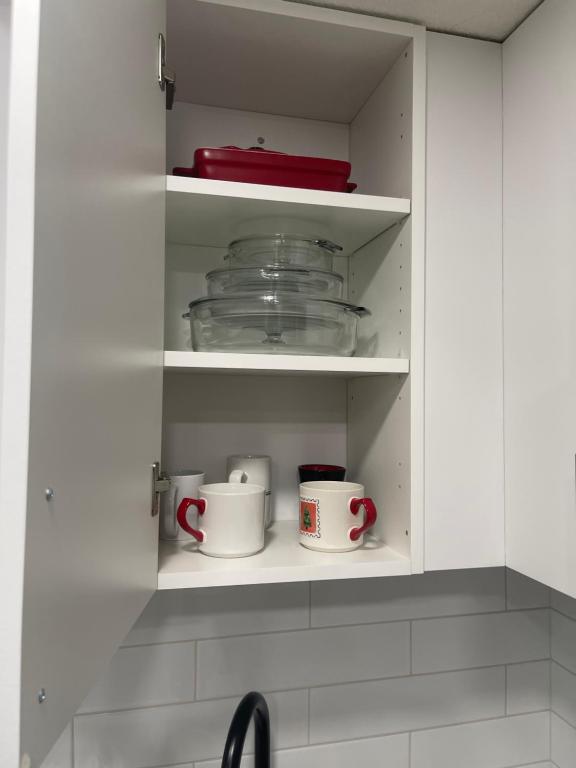 a kitchen cupboard with two mugs and bowls on it at Stylish 2 Bedroom suite in SW Edmonton close to Windermere and Edmonton International Airport in Edmonton
