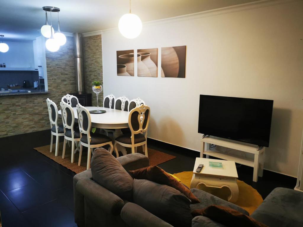 sala de estar con sofá, mesa y TV en Casa da Escola, en Paredes de Coura