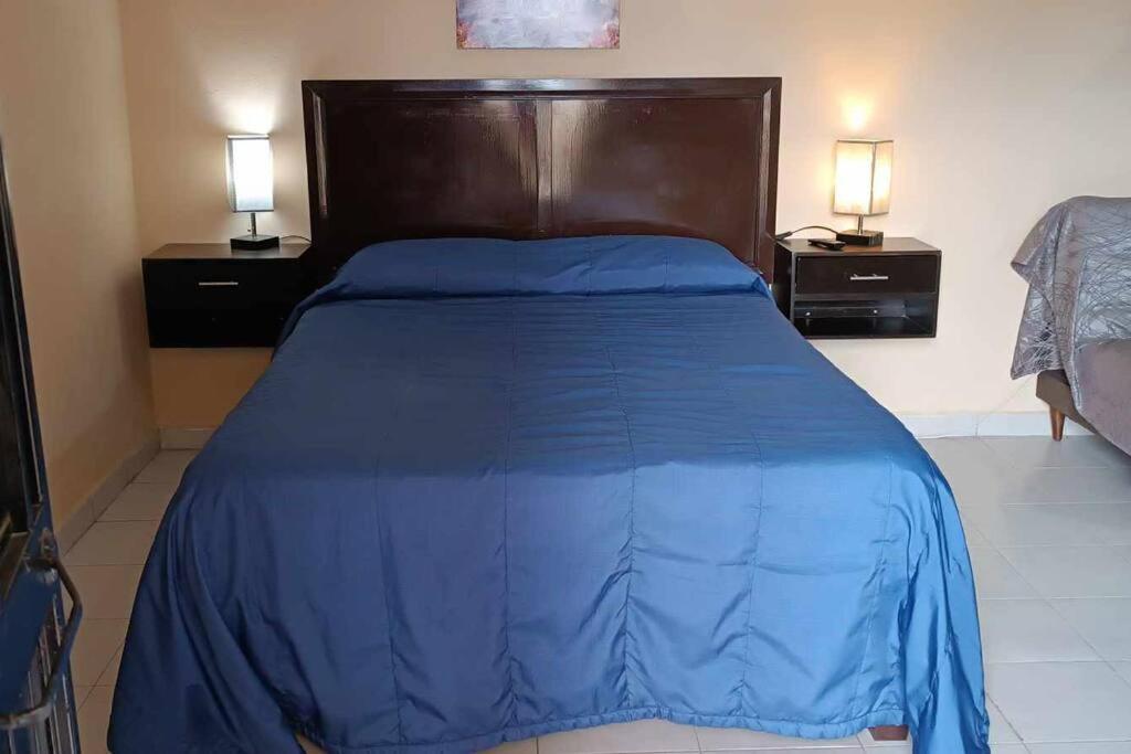 a bedroom with a blue bed with two night stands at Loft Flor de Pitaya in Cabo San Lucas