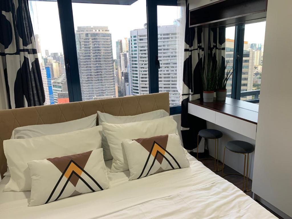 a bedroom with a bed with a view of a city at Air Residences in the Heart of Makati City - Great for Tourists, Staycations or Working Professionals in Manila