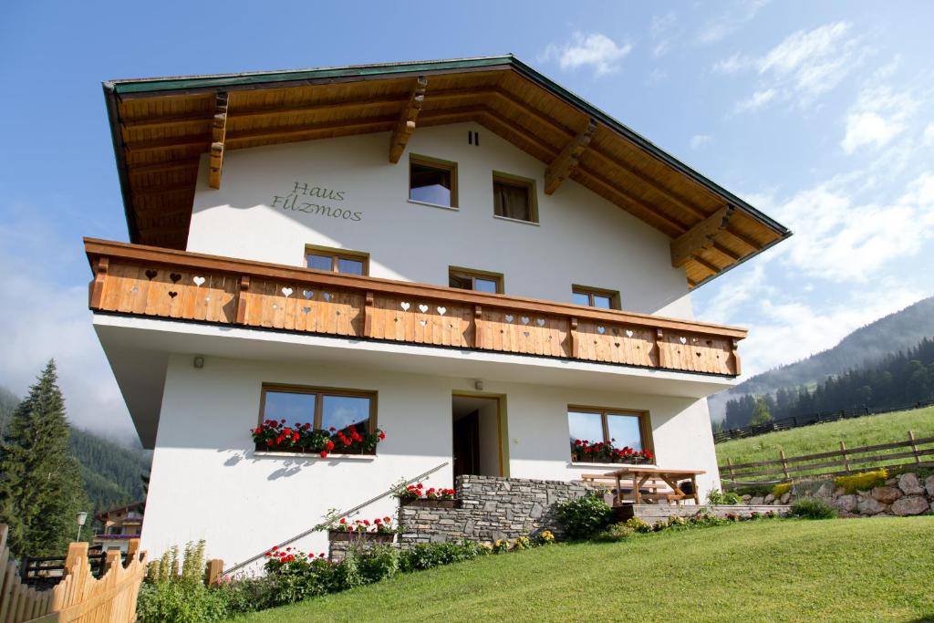 a large white building with a wooden roof at Haus Filzmoos in Filzmoos