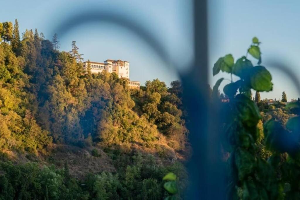 a building on top of a hill with trees at Artistic home with fantastic view of la Alhambra in Granada