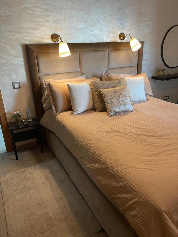 ein Schlafzimmer mit einem großen Bett mit Kissen in der Unterkunft Miramare Cosy appartement pied dans l'eau avec piscine in Mohammedia