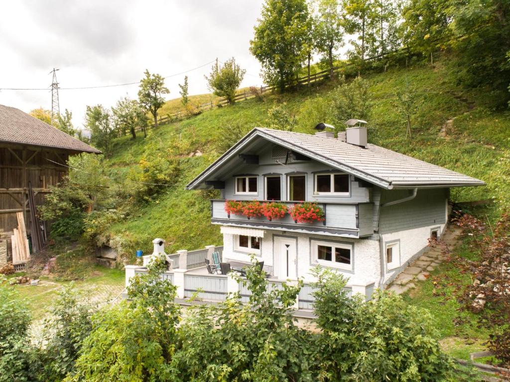 une maison sur une colline avec des fleurs sur elle dans l'établissement Resinger, à Matrei in Osttirol