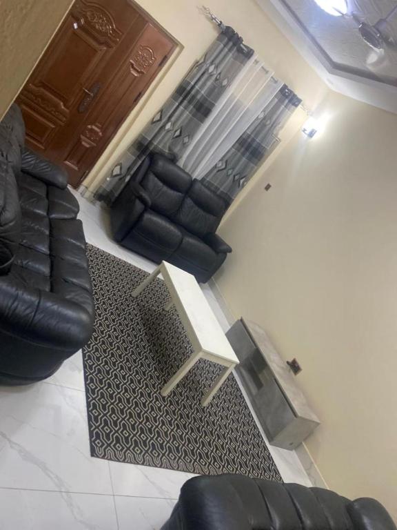 a living room with two black leather couches and a table at Two bedroom apartment Paradise estate Apt in Bureng