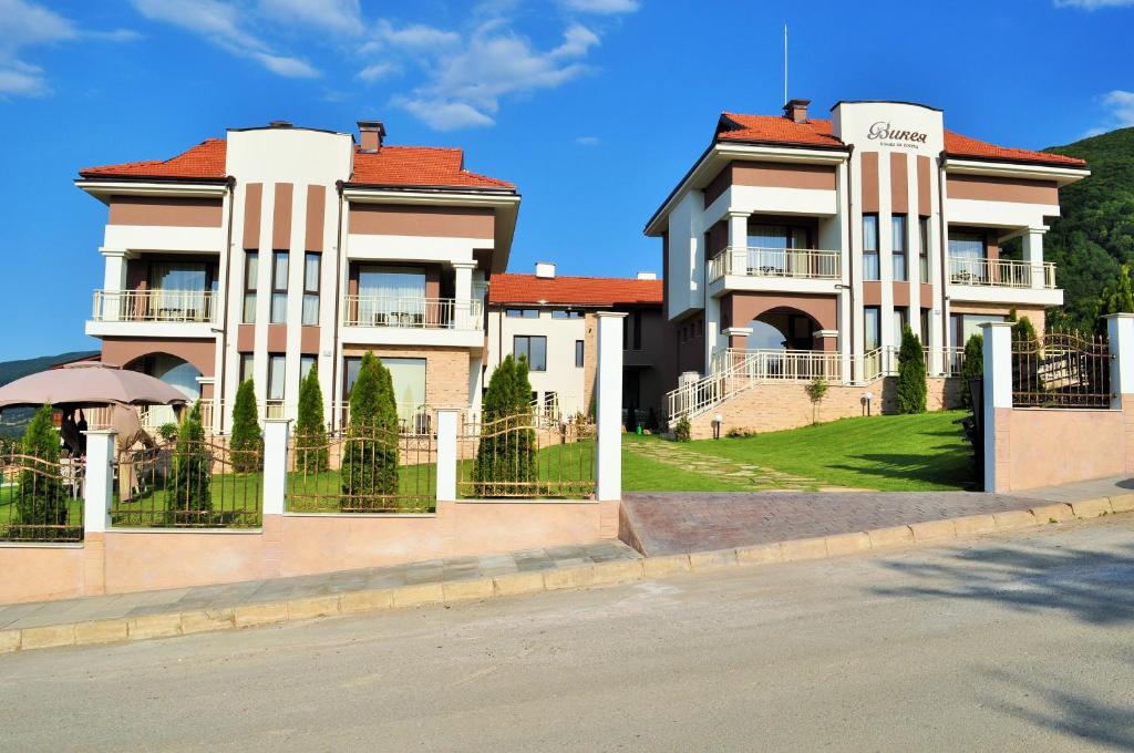 a large house with a fence in front of it at Vikeya Guest House in Sapareva Banya