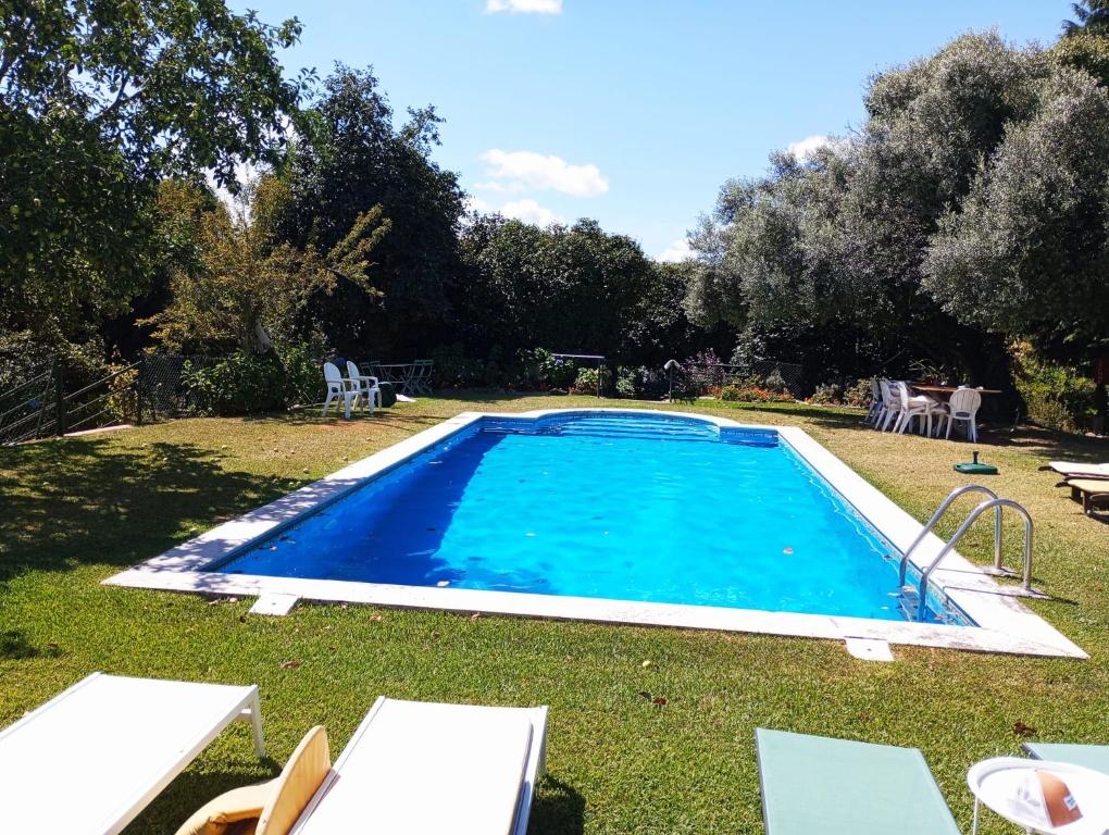 - une piscine dans une cour avec des chaises et des arbres dans l'établissement Quinta da Maínha - Charming Houses, à Braga
