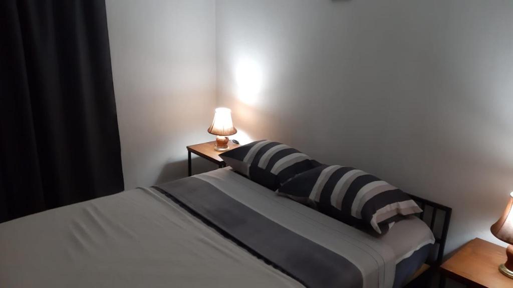 a bedroom with a bed with two lamps on two tables at Departamento Céntrico in Oberá