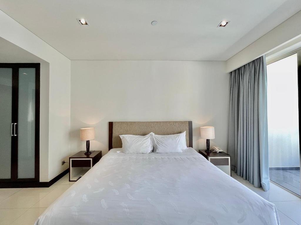 a bedroom with a large white bed with two lamps at Studio With SeaView in Nha Trang