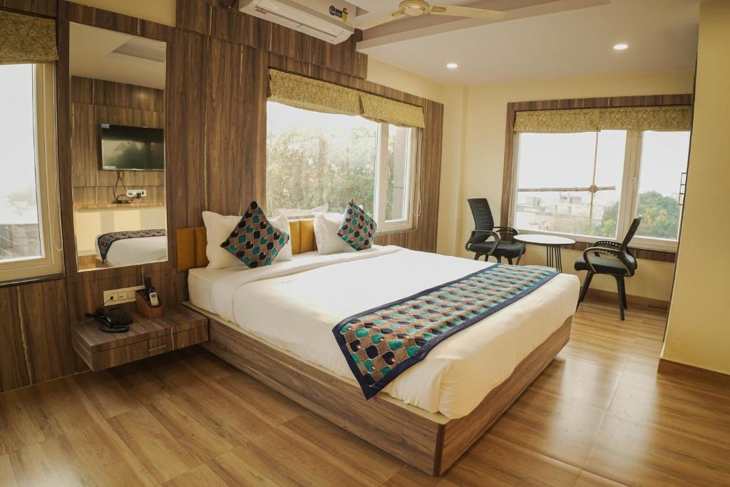 a bedroom with a large bed and a table and chairs at Hotel Grand Residency in Jamshedpur