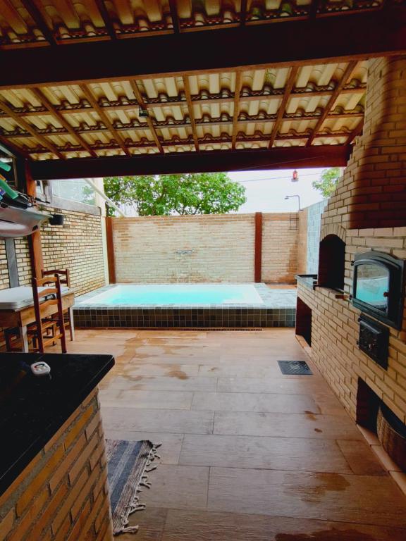 un patio al aire libre con piscina y pared de ladrillo en Casa com piscina privativa, 2 suítes, Sahy. en Mangaratiba