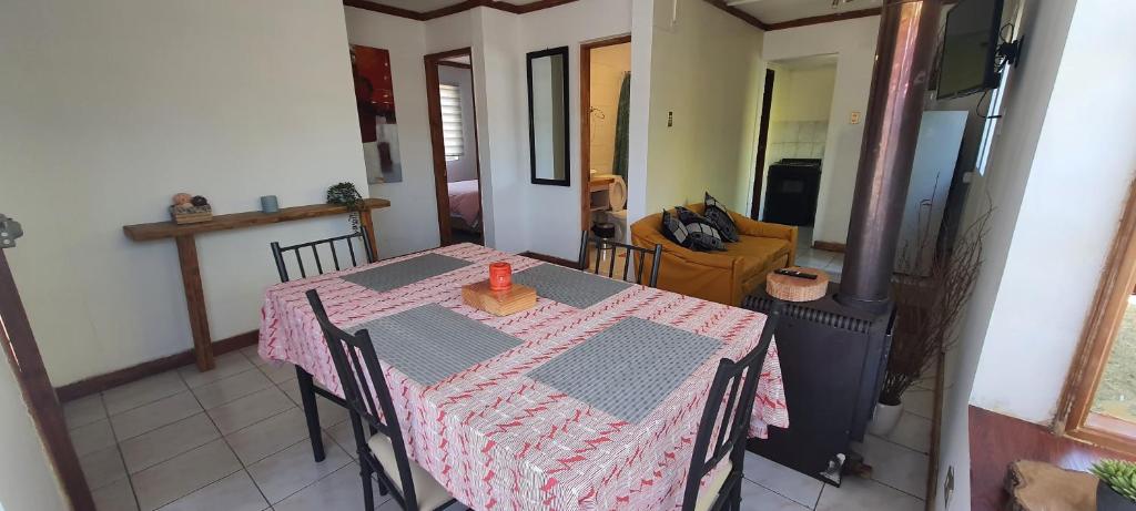 uma mesa de jantar com uma toalha de mesa rosa e branca em Casa variante internacional em Pucón
