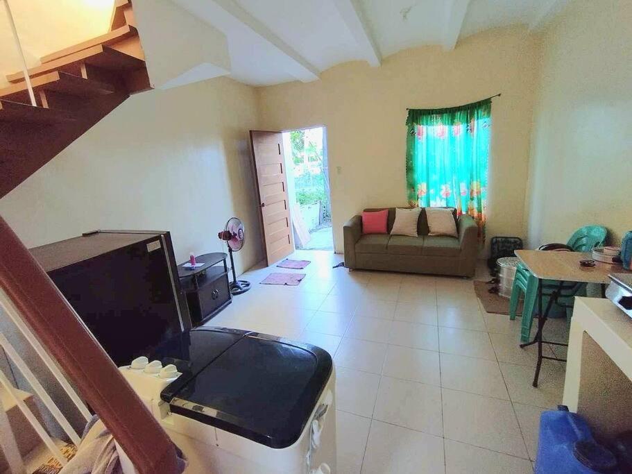 a living room with a couch and a tv at Town House Good for Family Stay in General Trias