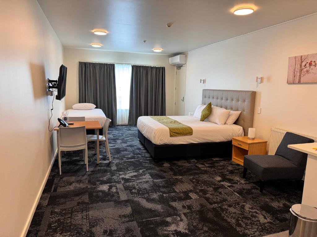 ハミルトンにあるZeta Motelのベッドとデスクが備わるホテルルームです。